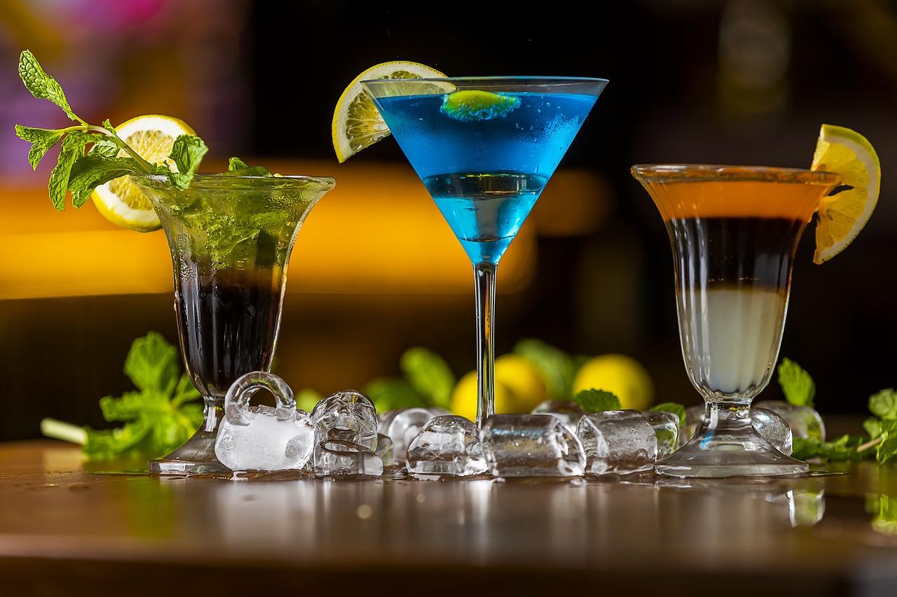 Professionele barman bereidt cocktails achter een elegante cocktailbar aan huis tijdens een gezellig thuisfeest